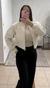 Béžová dámska bomber bunda Ola Voga so skráteným strihom, nosená s čiernymi nohavicami